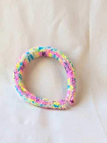 This is a detail image of a rainbow shaveded punch needle headband. The colors ranges from bright yellow to teal to pink to purple. Holo Rainbow Headband 01 | dancing arms | Punch Needle Headband