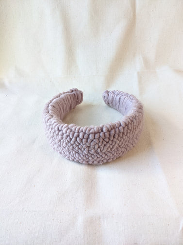 This is an image of a punch needle headband made with lavender chunky merino wool. Dancing arms punch needle hair accessories made in Los Angeles.