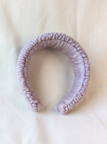 This is an image of a punch needle headband made with lavender chunky merino wool. Dancing arms punch needle hair accessories made in Los Angeles.