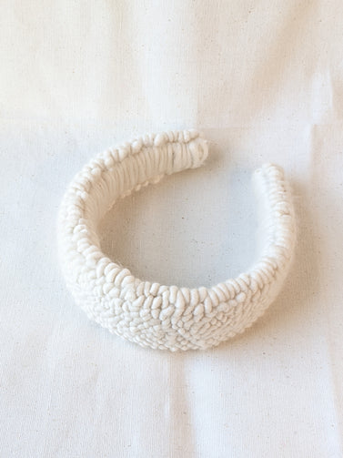 This is an image of a punch needle headband made with ivory chunky merino wool. Dancing arms punch needle hair accessories made in Los Angeles.