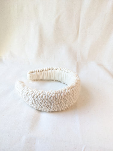 This is an image of a punch needle headband made with ivory chunky merino wool. Dancing arms punch needle hair accessories made in Los Angeles.