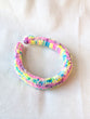 This is a detail image of a rainbow shaveded punch needle headband. The colors ranges from bright yellow to teal to pink to purple. Holo Rainbow Headband 01 | dancing arms | Punch Needle Headband