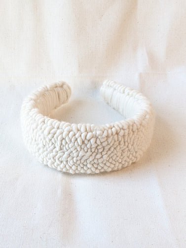 This is an image of a punch needle headband made with ivory chunky merino wool. Dancing arms punch needle hair accessories made in Los Angeles.