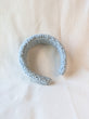This is an image of a punch needle headband made with baby blue chunky merino wool. Dancing arms punch needle hair accessories made in Los Angeles.